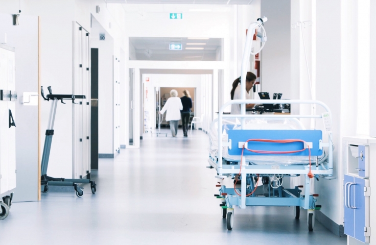 Hospital corridor with a bed and patients walking
