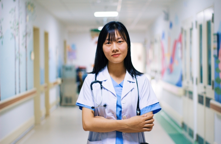 Female doctor posing in a hospital corridor